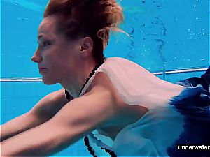 ginger-haired babe swimming bare in the pool